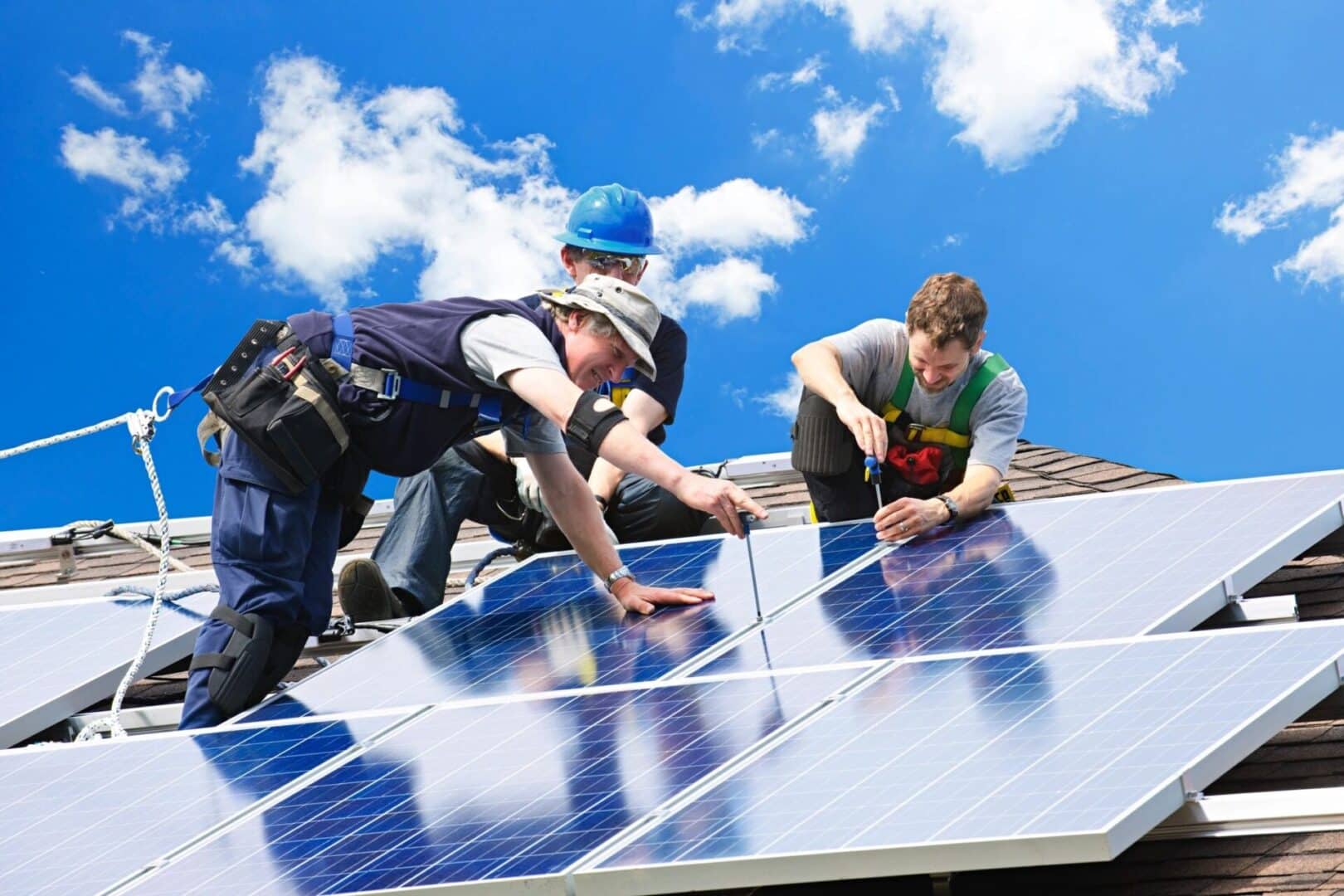 Three men working on a solar panel.