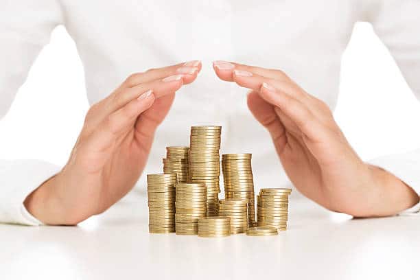 Savings protection Close up of female hands covering stack of golden coins ers: schedule Shielding Your Investment stock pictures, royalty-free photos & images