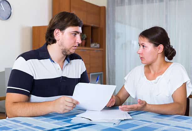 spouses discussing bills Serious spouses discussing banking statement at home Review Contracts covered Thoroughly\ stock pictures, royalty-free photos & images