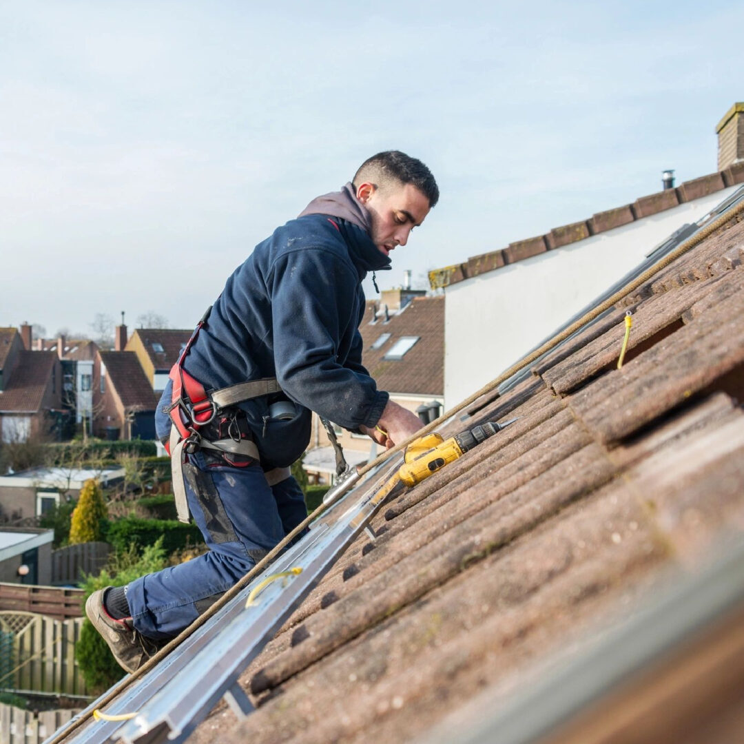 A man working on the roof of his house.